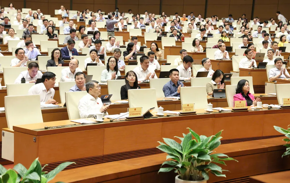 Thủ tướng Lê Minh Hưng và các đại biểu tán thành Quốc hội thông qua các luật sáng 24-8. Ảnh QUANG PHÚC