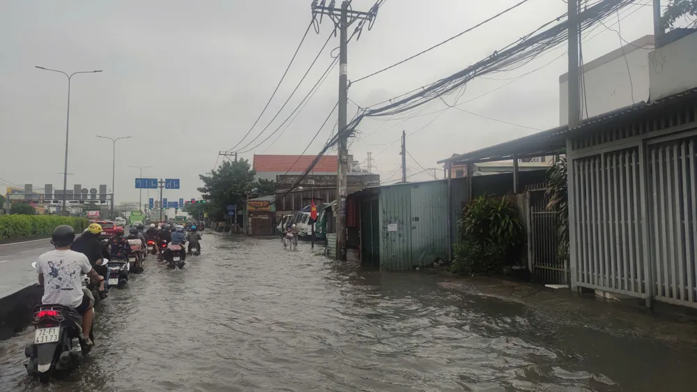 Triều cường lên cao khiến đoạn đường trên quốc lộ 1A, đoạn qua phường Thới An, TPHCM bị ngập. Ảnh: THANH HIỀN