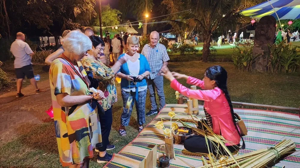 Khách tàu biển quốc tế tìm hiểu về cách làm hoa từ lá dừa tại Làng Du lịch Bình Quới đầu tháng 3-2023