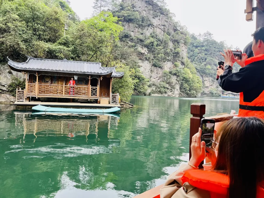 Đoàn du khách TPHCM tham quan cảnh đẹp và thưởng thức giọng hát trong trẻo do một nữ nghệ sĩ thực hiện (ảnh) tại Trương Gia Giới thuộc tỉnh Hồ Nam, Trung Quốc