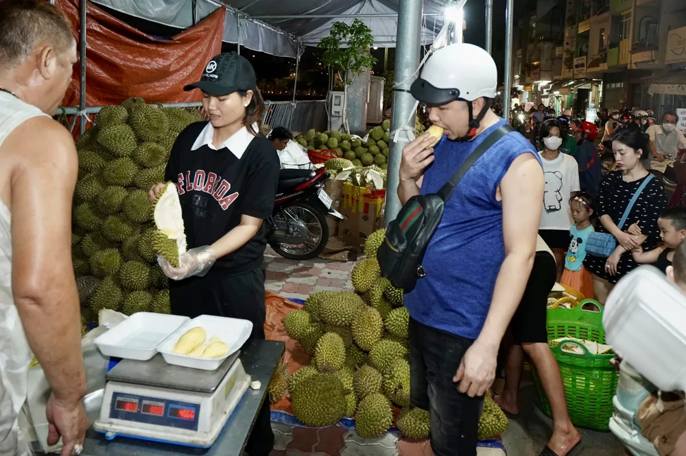 Người dân mua và thưởng thức sầu riêng ngay tại gian hàng tối 4-6.jpg