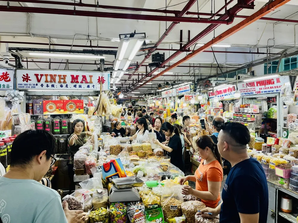 Người tiêu dùng, trong đó có du khách Trung Quốc, chọn mua đồ khô các loại tại chợ An Đông, quận 5, TPHCM.jpg