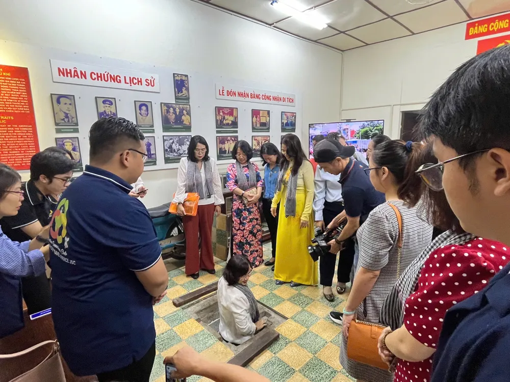 游客参观并体验第十郡抗美时期的盛放武器秘密地道。（图：诗红）