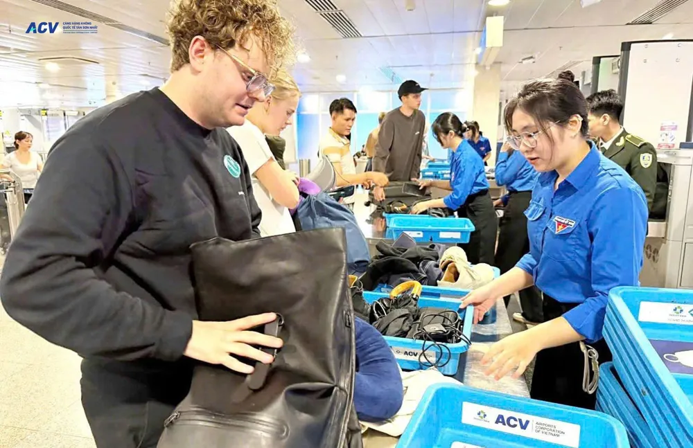 Khách làm thủ tục soi chiếu hành lý tại sân bay.jpg
