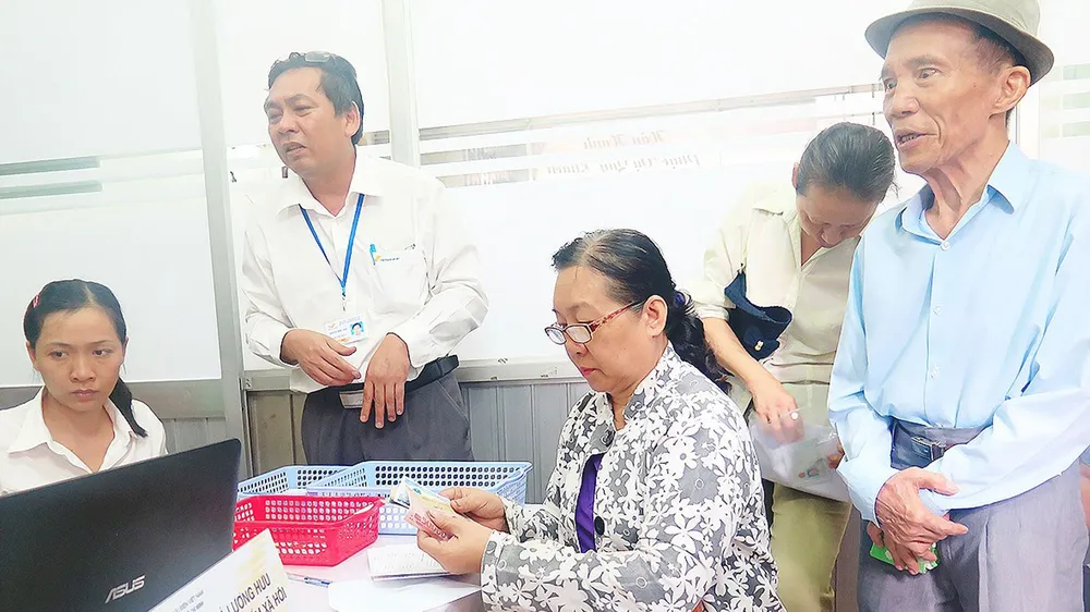 Khoảng 210.000 người có công, hưu trí, bảo trợ ở TPHCM được lãnh tiền chế độ tại nhà ảnh 2