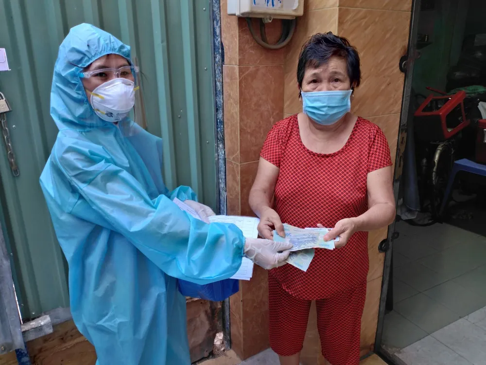 Người lao động tự do trên địa bàn quận 11 nhận tiền hỗ trợ. Ảnh: ĐÌNH LÝ