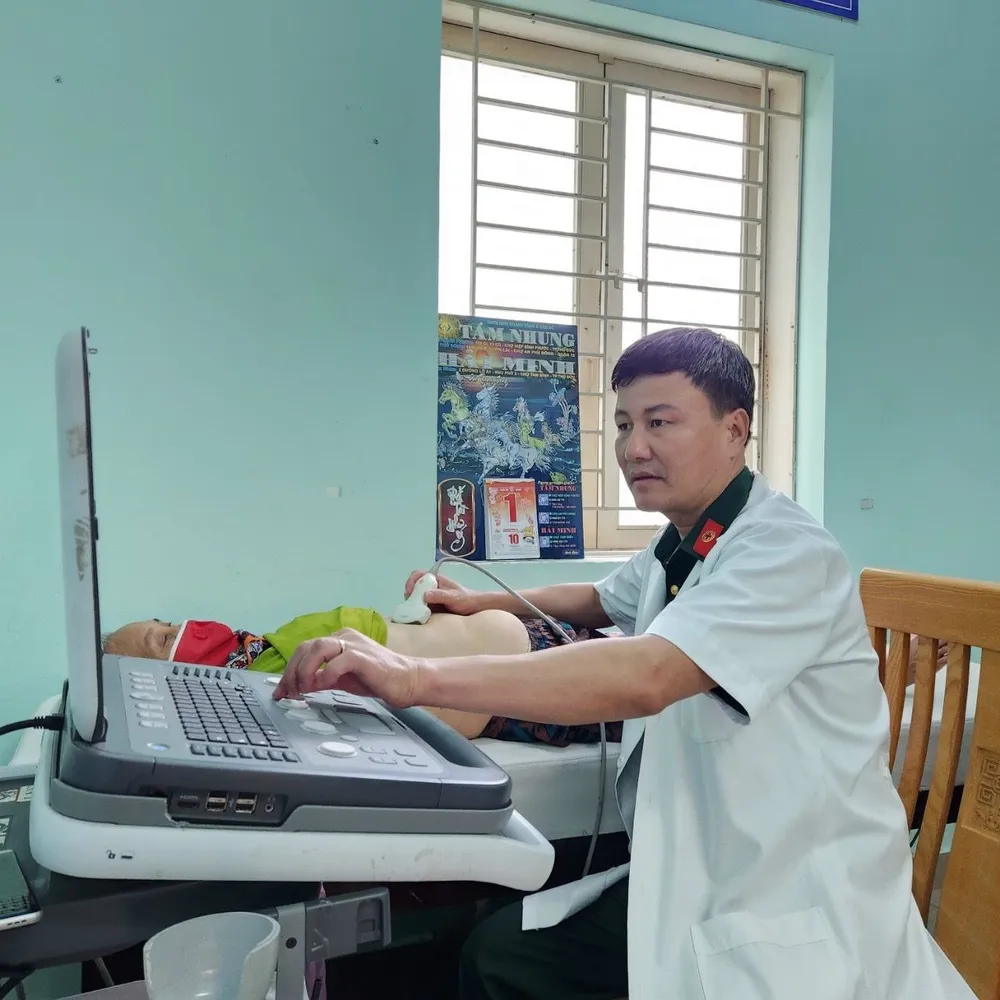 Bác sĩ Nguyễn Xuân Thành thực hiện siêu âm, khám bệnh cho người dân. Ảnh: TRẦN YÊN