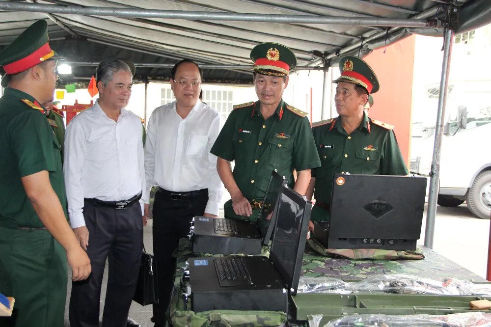 Trung tướng Nguyễn Văn Nam (thứ 2, bên phải sang) giới thiệu với các đồng chí lãnh đạo TPHCM về vũ khí, trang thiết bị quân sự mới tại buổi lễ. Ảnh: TRẦN YÊN