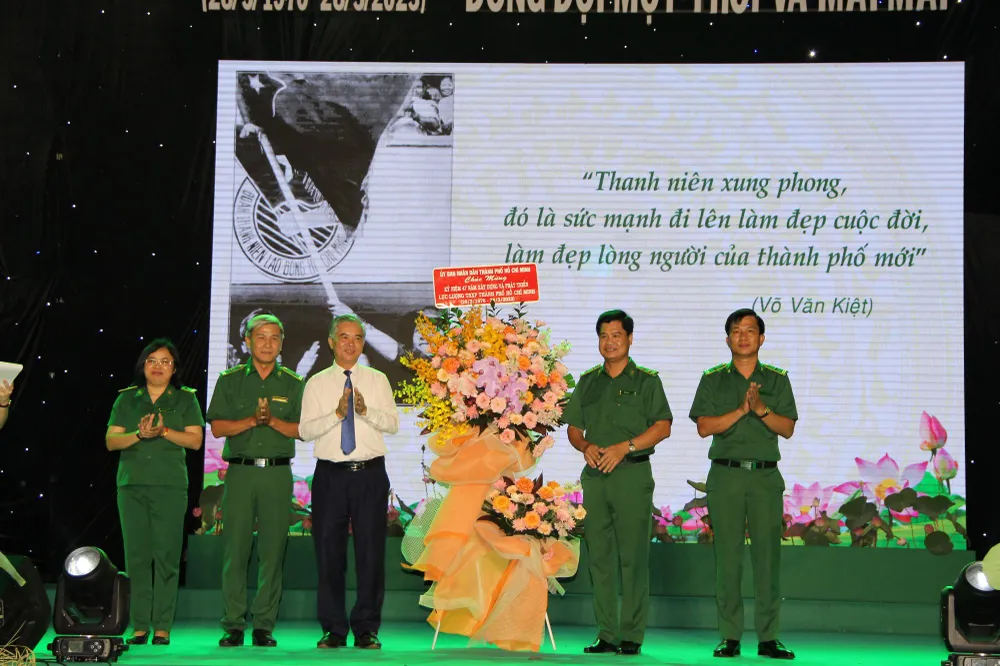 Phó Chủ tịch UBND TPHCM Ngô Minh Châu tặng hoa chúc mừng Lực lượng TNXP TPHCM. Ảnh: TRẦN YÊN