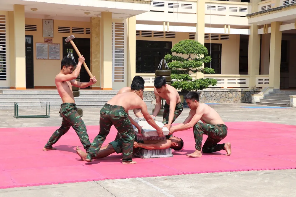 Các chiến đấu viên Tiểu đoàn Đặc công 60 thực hiện vận khí công nội dung Nằm bàn chông đập đá. Ảnh: TRẦN YÊN