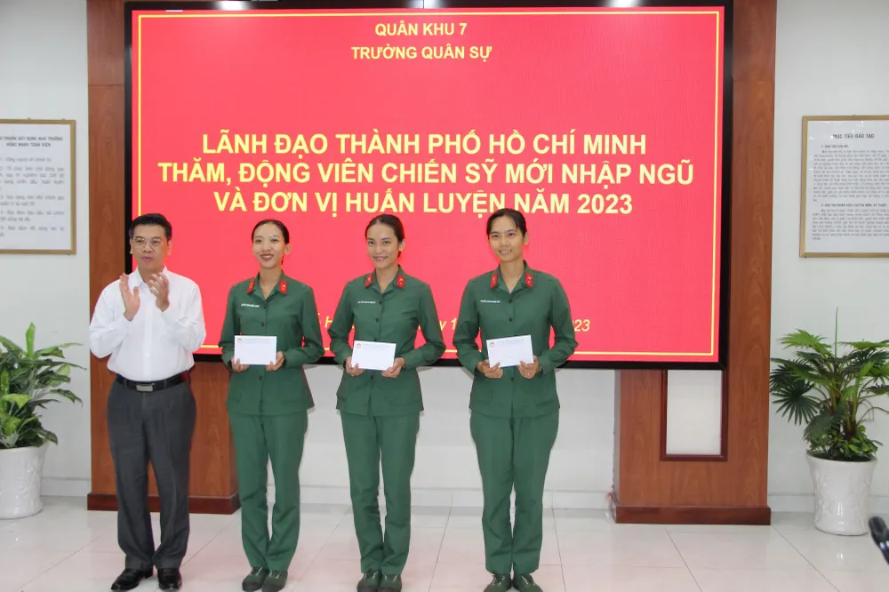 Đồng chí Nguyễn Văn Dũng trao quà cho 3 nữ chiến sĩ mới tại Trường Quân sự Quân khu 7. Ảnh: TRẦN YÊN