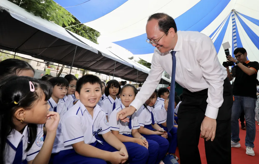 Phó Bí thư Thành ủy TPHCM Nguyễn Hồ Hải chung vui cùng các em học sinh đầu năm học mới. Ảnh: DŨNG PHƯƠNG