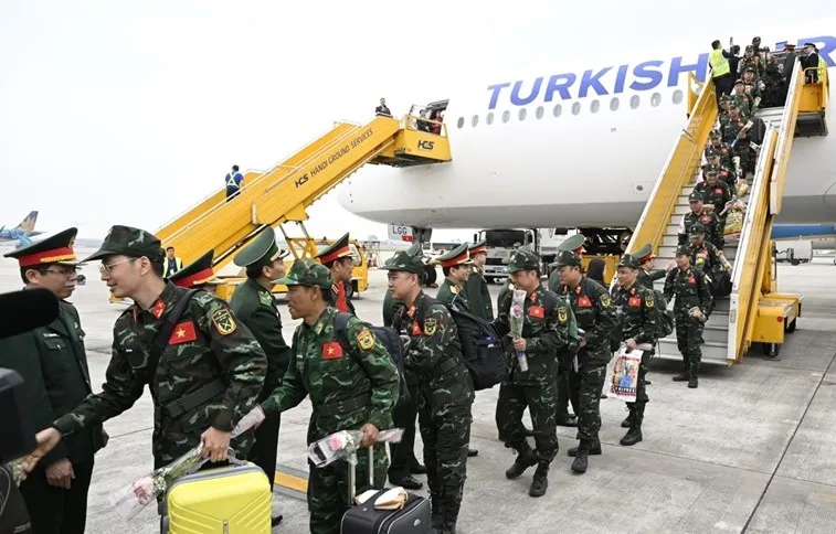 Đoàn công tác rời máy bay trong sự chào đón của lãnh đạo Bộ Quốc phòng và các đại biểu. Ảnh: BQP