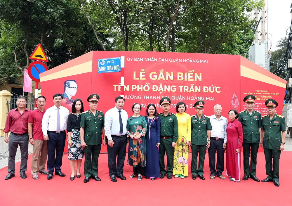 Gia đình Thiếu tướng, Anh hùng lực lượng vũ trang nhân dân Đặng Trần Đức cùng các đại biểu bên tên biển phố mang tên Đặng Trần Đức tại sự kiện. Ảnh T.B
