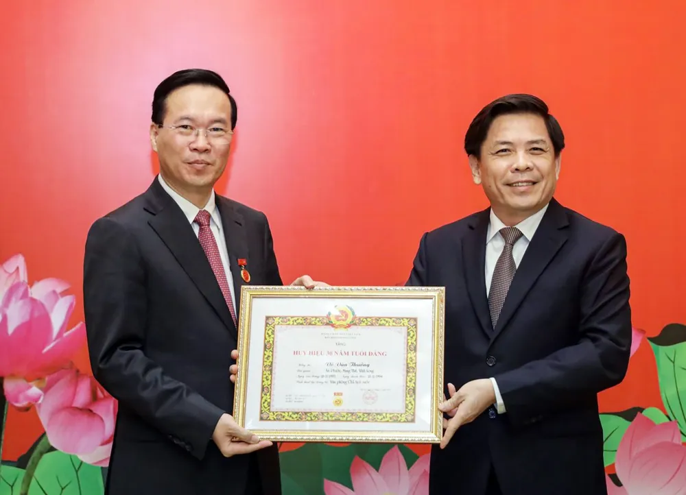 Bí thư Đảng ủy Khối các cơ quan Trung ương Nguyễn Văn Thể trao Huy hiệu 30 năm tuổi Đảng tặng Chủ tịch nước Võ Văn Thưởng. Ảnh: VPCTN