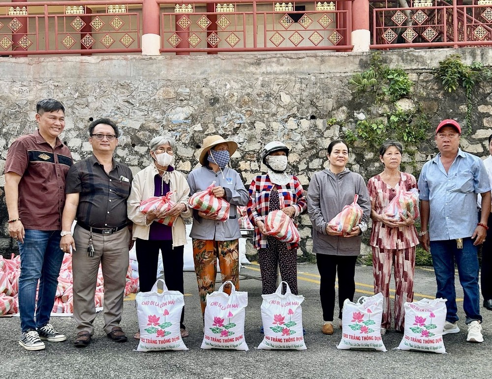 本市头顿崇正天后宫理事长邹国荣（左二）向贫困者派发盂兰节礼物