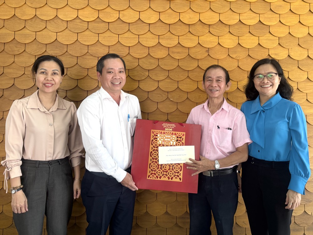 市委宣教与民运处副主任段文同该处干部向华人退休干部梁鸿德赠送新年礼物。