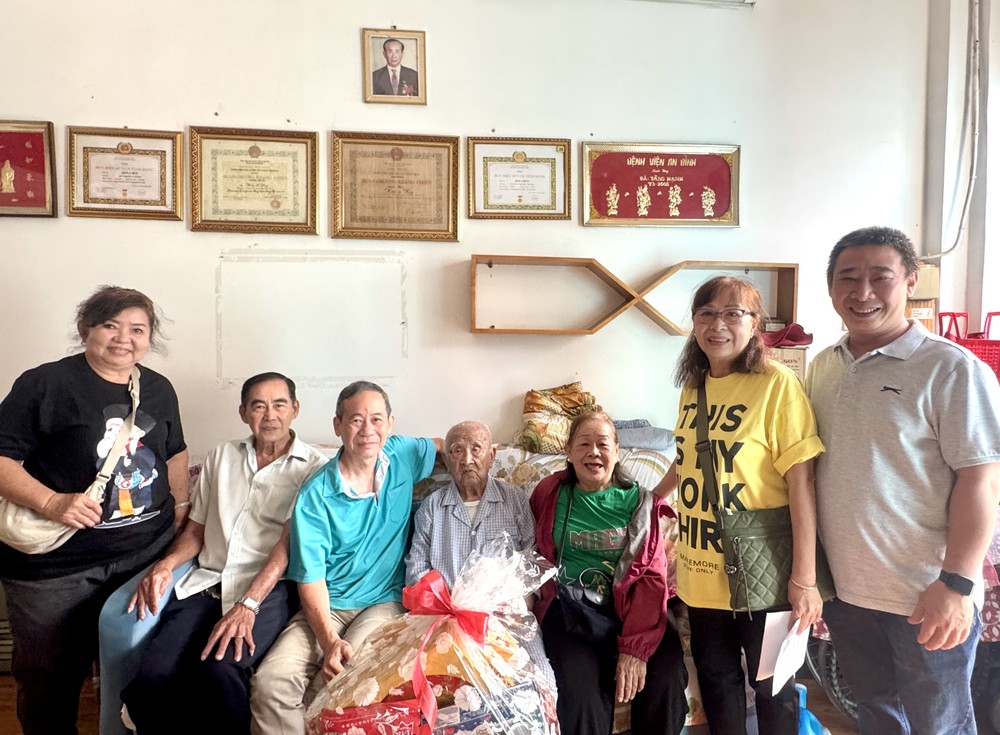 海南琼府会馆理事会代表团向华人革命老前辈韩晖光赠送新年礼物。