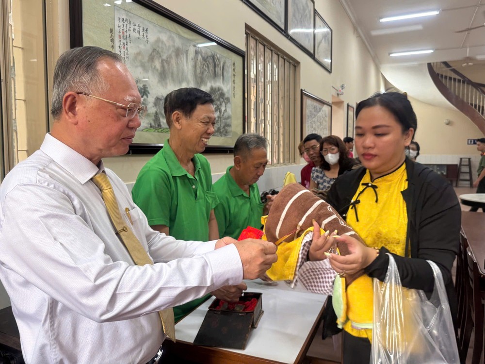 穗城会馆理事长盧耀南向善信派“阿婆”利是。