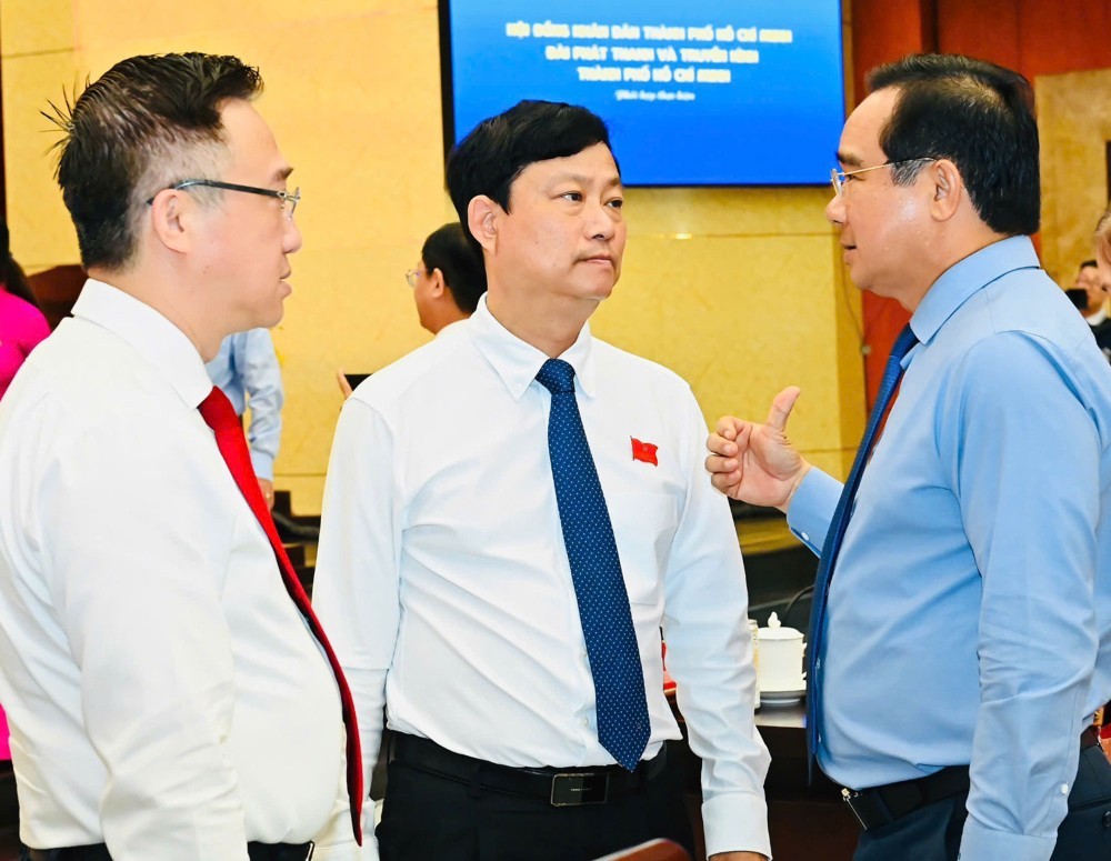 胡志明市人委会主席阮文得在2025年年终例行会议上，与市人民议会主席武文明及市委副书记邓明通进行交流。