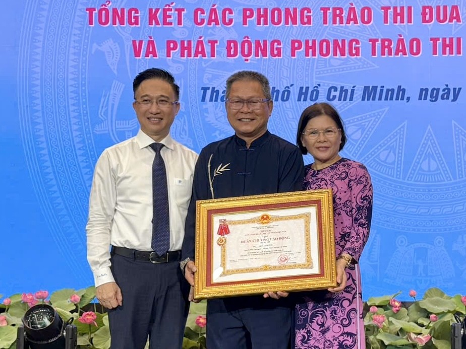 华人退休干部曾锦荣（中）荣获二等劳动勋章。