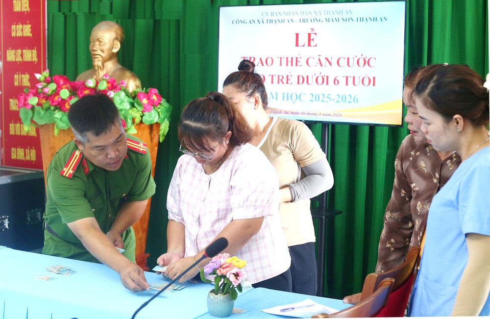 盛安乡公安长赵洪德中校向儿童监护人签发身份证。