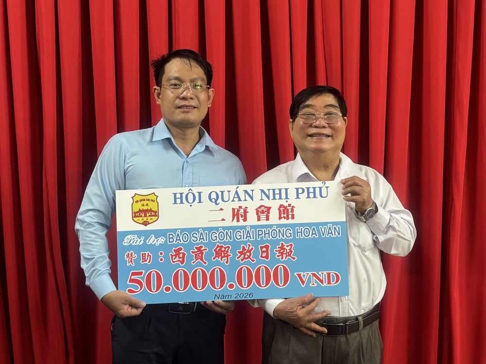 胡志明市福建二府会馆理事长彭伟强（右）向本报领导移交5000万元赞助经费。