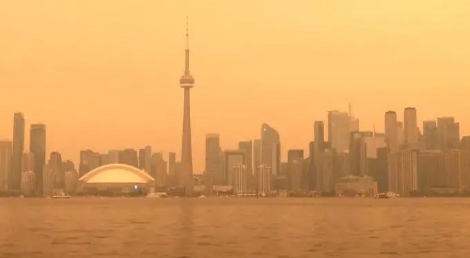 森林野火产生的浓烟笼罩多伦多市，天空被染成橙色。图：Al Jazeera