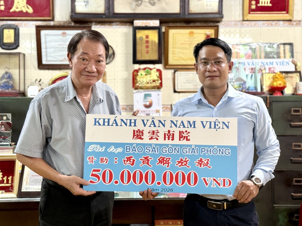 庆云南院住持周华邦（左）将5000万元赞助经费移交予《西贡解放报》采编部主任、华文电子版负责人文忠孝。VD摄