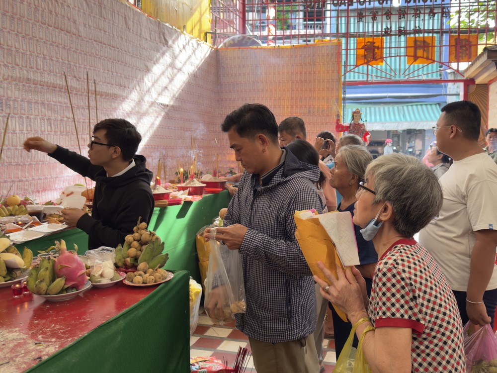 善信携带供品前来祭拜先人，并依序上香祈福。