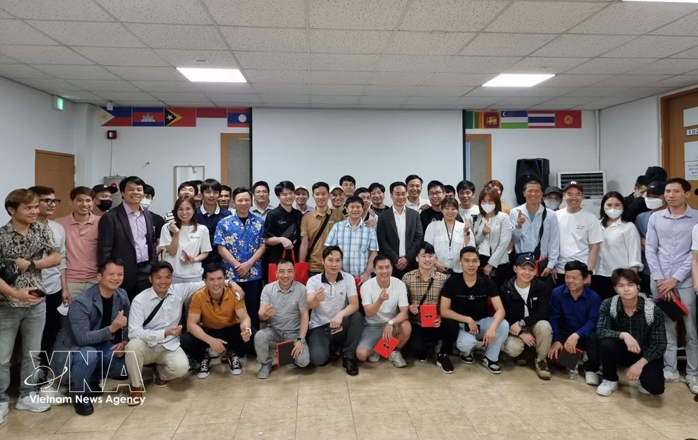 在昌原（韩国）的越南劳动者与各组织方和赞助方代表在提高昌原越南劳动者法律知识咨询会上合影留念。图自越通社