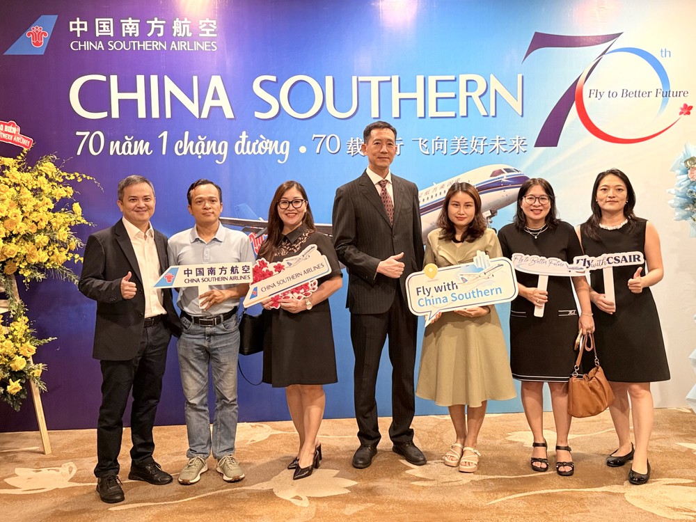 中国南方航空胡志明市营业部总经理黄翔（中）、副经理雷远志（左一）与客户合照留念。VD摄