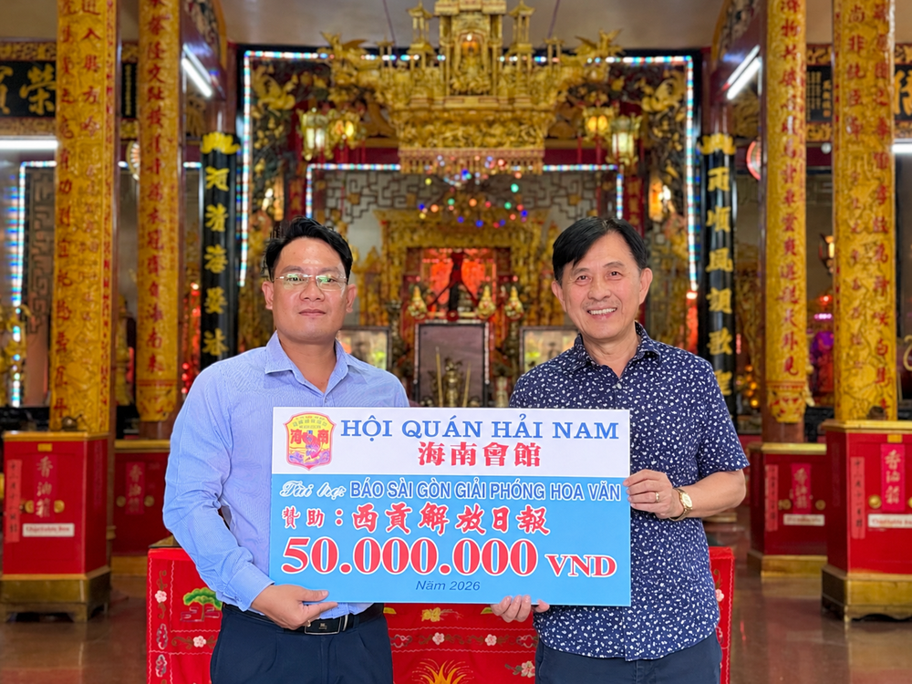 海南会馆理事长林明辉（右）将5000万元赞助经费移交予《西贡解放报》采编部主任、华文电子报负责人文忠孝。