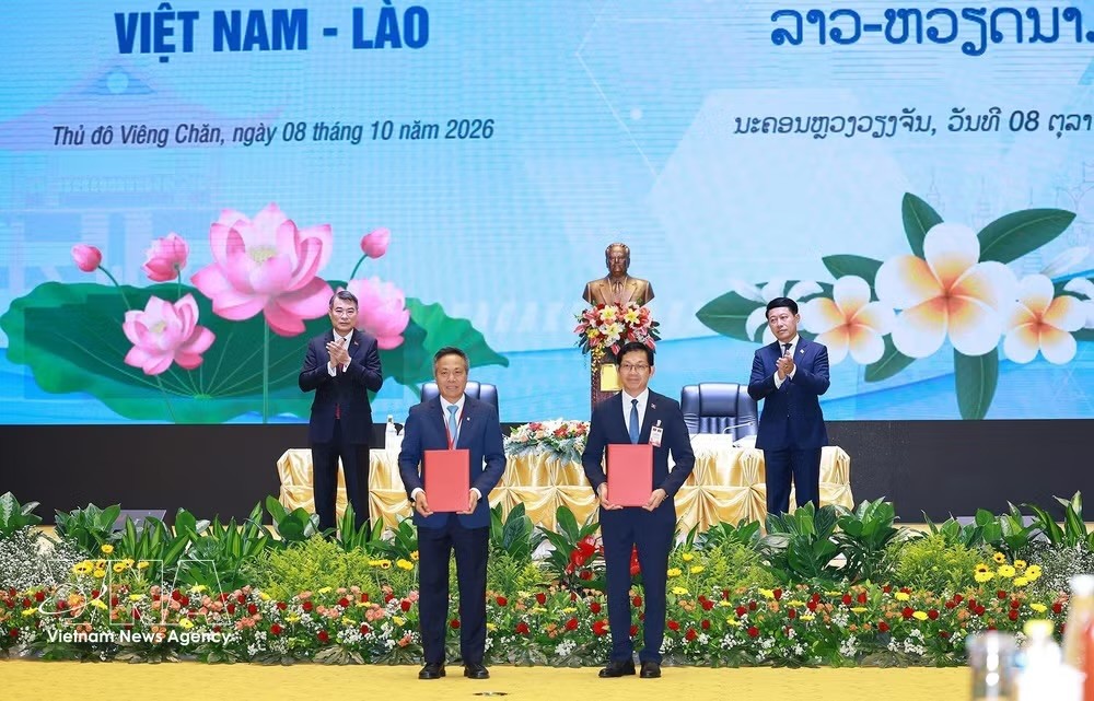 越南政府总理黎明兴和老挝政府总理沙伦塞·贡马西共同见证两国有关机构和企业移交和签署17项投资许可证及项目合作协议。图片来源：越通社