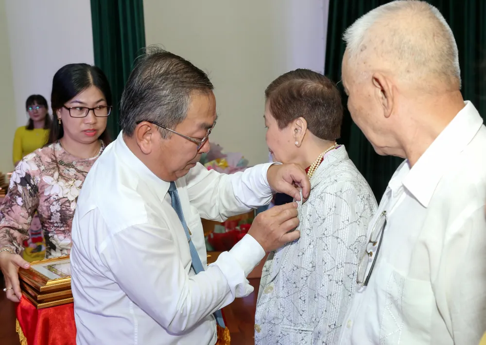 Bí thư quận ủy Quận 8 Võ Ngọc Quốc Thuận trao Huy hiệu 55 tuổi Đảng cho các đảng viên. Ảnh: THẢO LÊ