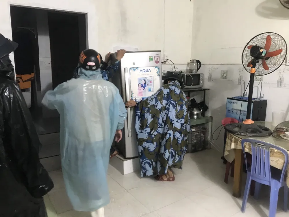 Lực lượng chức năng giúp người dân dọn đồ chạy lũ