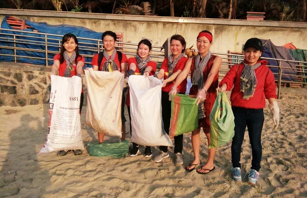 Nguyễn Ngọc Ánh (thứ 3 từ trái sang) cùng các tình nguyện viên nhặt rác tại bãi biển. Ảnh: NVCC