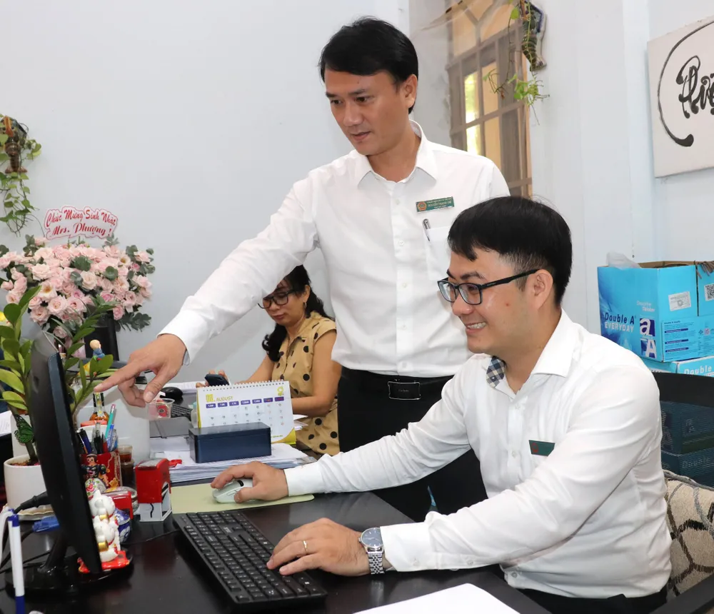 Anh Nguyễn Văn Tuấn Anh và Nguyễn Thanh Trí (từ phải qua) trao đổi việc ứng dụng công nghệ thông tin vào hoạt động chuyên môn tại đơn vị.JPG