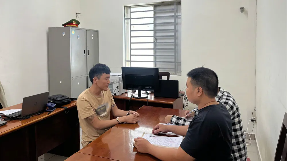 Công an lấy lời khai Huỳnh Duy Chiến (bìa trái)