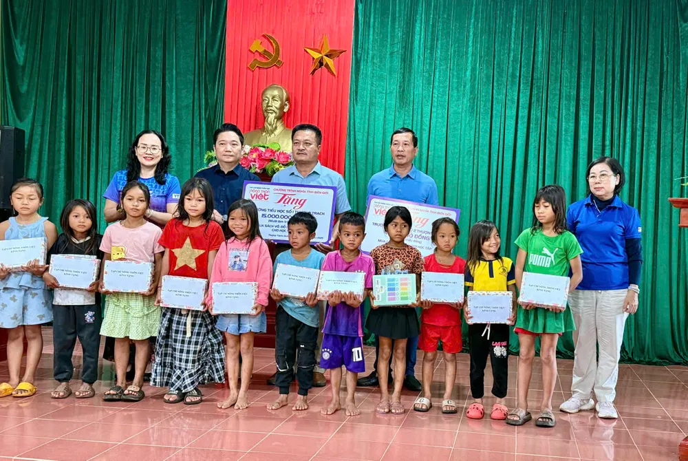 Đại diện Ban tổ chức chương trình Nghĩa tình Biên giới - Tạp chí Nông thôn Việt trao quà cho các em..jpg