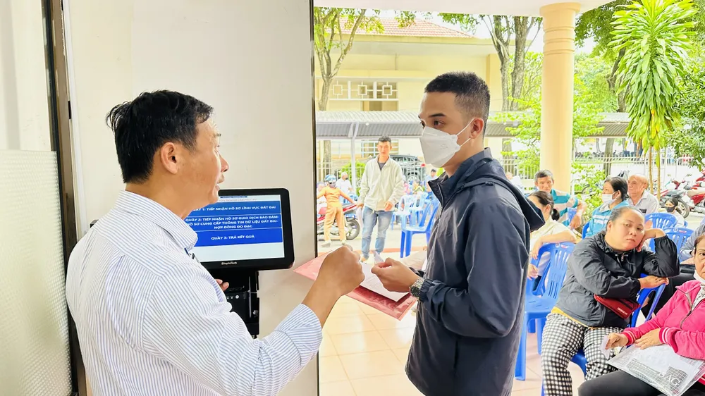 Do lượng người dân đến làm thủ tục đất đai đông, Chi nhánh Văn phòng Đăng ký đất đai Châu Đức phải cử người hỗ trợ bấm số. Ảnh: QUANG VŨ