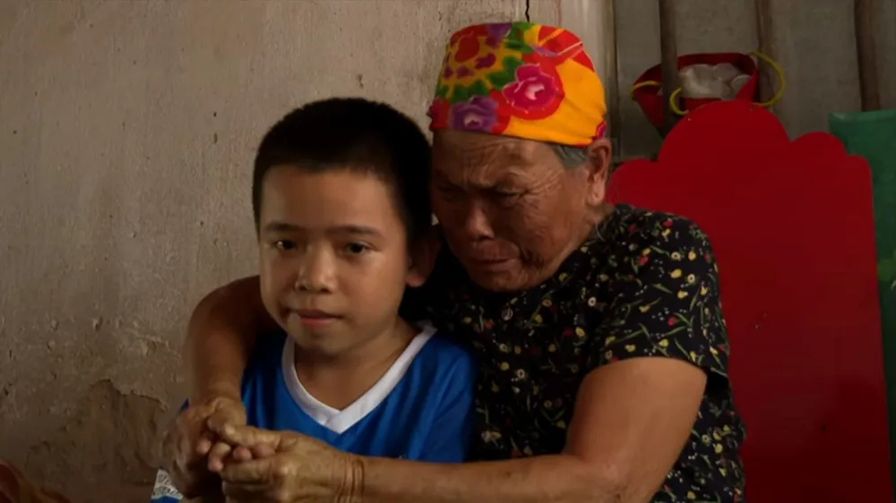 Bà Từ Thị Thà và cháu nội trong ngôi nhà lụp xụp