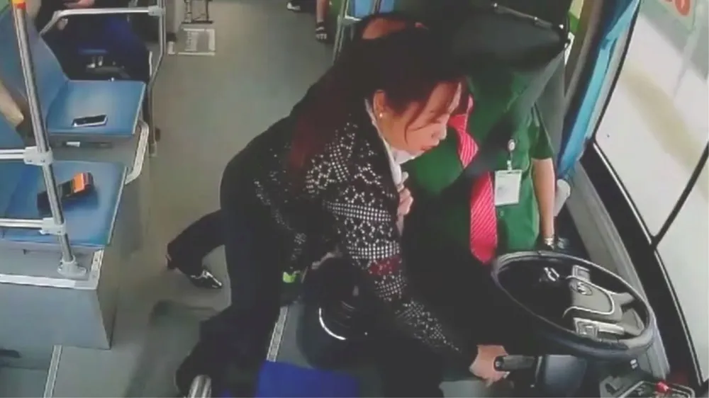 Tài xế (áo xanh) bất ngờ đột quỵ, nữ nhân viên nhanh trí tắt chìa khóa xe. Ảnh chụp từ clip