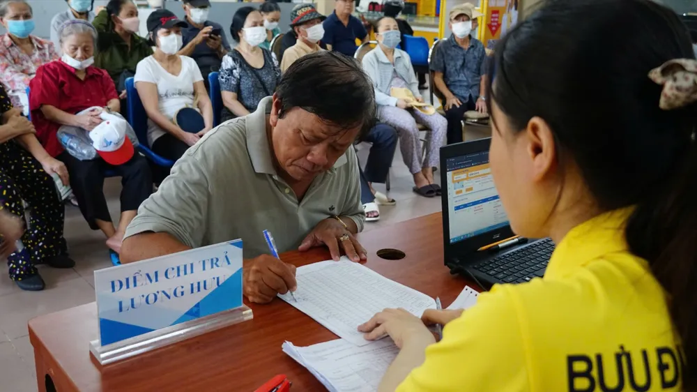 Nhân viên bưu điện TPHCM chi trả lương hưu cho người hưởng.jpg