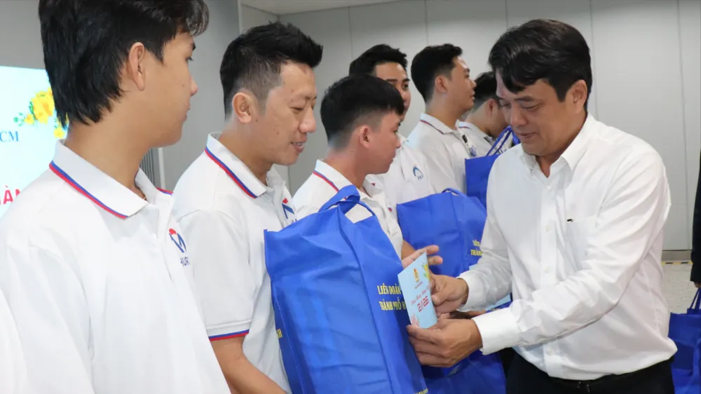 Chủ tịch LĐLĐ TPHCM Bùi Thanh Nhân tặng quà người lao động tại ga Metro Bến Thành. Ảnh: THÁI PHƯƠNG