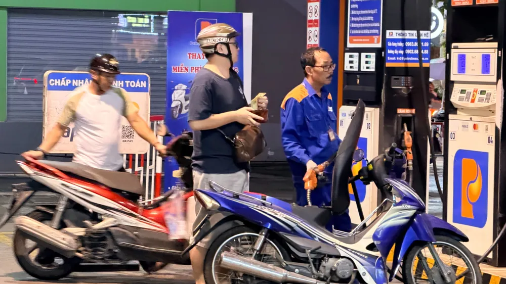 Người dân đổ xăng tại cửa hàng xăng dầu Petrolimex 26, phường Xuân Hòa, TPHCM, tối 6-3 (ẢNH: HOÀNG HÙNG)