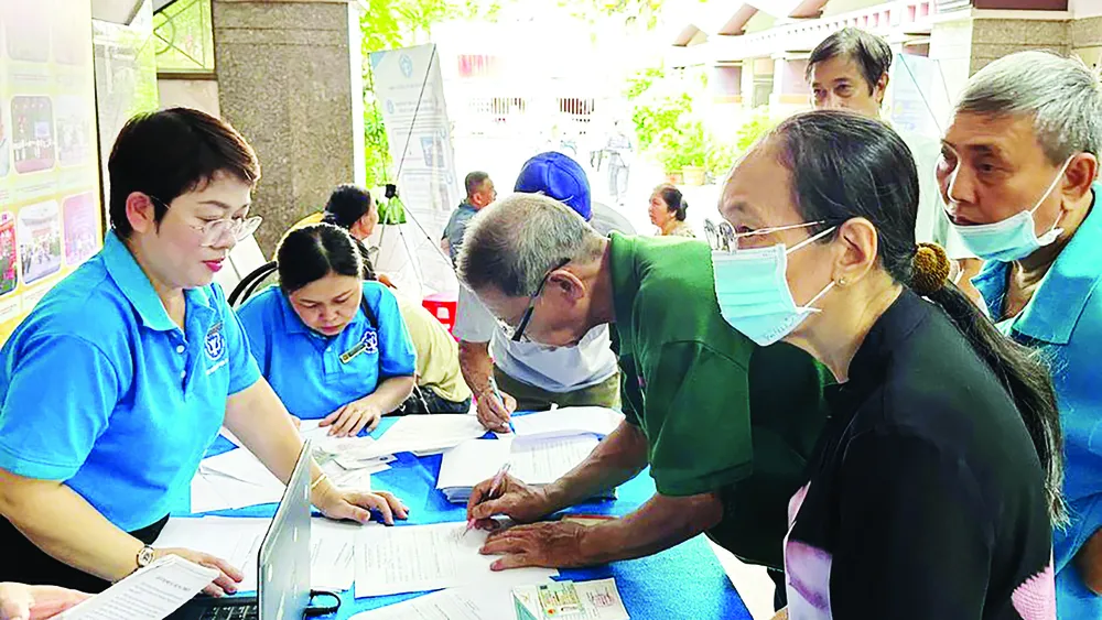 Chuyên viên BHXH TPHCM tư vấn chính sách BHYT, BHXH cho người dân (ẢNH: ĐÔNG SƠN)