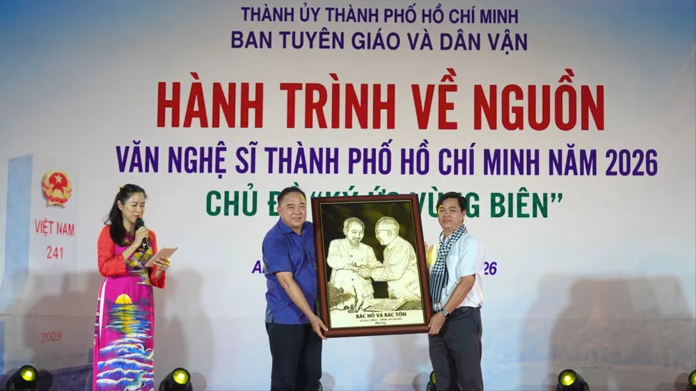 Bí thư Đảng ủy, Chủ tịch HĐND xã Ba Chúc Phạm Minh Hiền tặng bức tranh "Bác Hồ và Bác Tôn" cho Phó Trưởng Ban Thường trực Ban Tuyên giáo và Dân vận Thành ủy TPHCM Lê Văn Minh. Ảnh: THÚY BÌNH