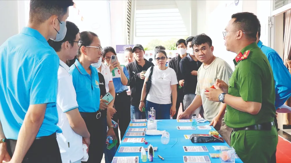 Công nhân tìm hiểu về cách phòng, chống ma túy tại ngày hội. ẢNH: HỒNG HẢI