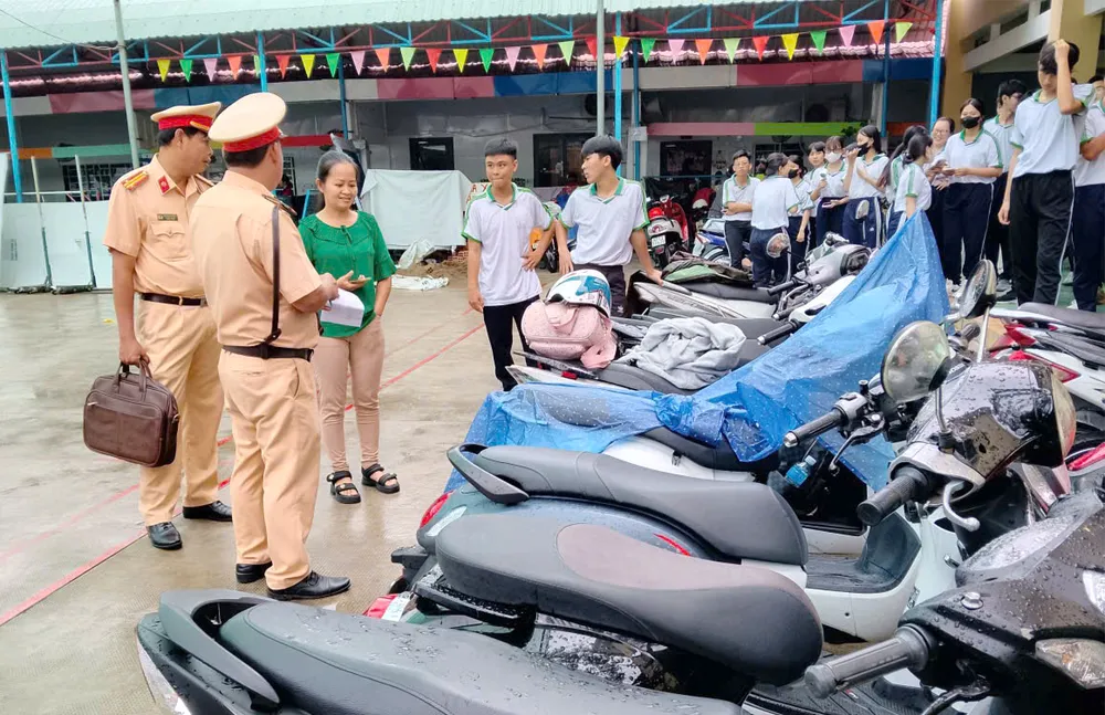 Lực lượng Cảnh sát giao thông Công an tỉnh An Giang kiểm tra bãi giữ xe một trường học trên địa bàn. Ảnh: NAM KHÔI